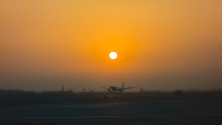 A plane landing at Dubai Airport, United Arab Emirates, at sunrise.の写真素材