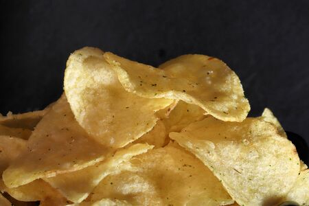 close-up delicious chips on black ground with sauce