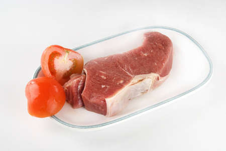 Fresh steak ready for grilling with tomatoesの写真素材
