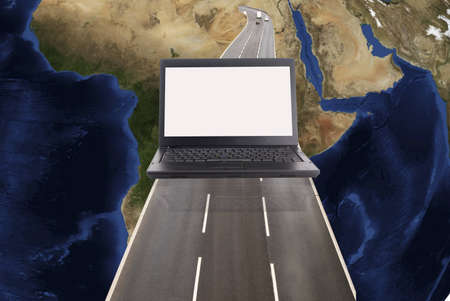 Technology concept with laptop world map and roadの写真素材