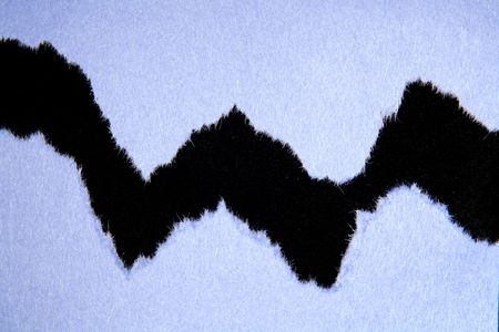 Ripped blue paper on black backgroundの写真素材