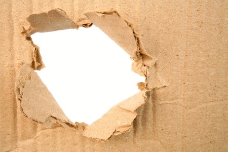 Hole ripped in corrugated cardboard   の写真素材