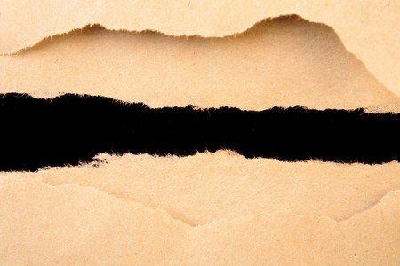 Hole ripped in brown paperの写真素材