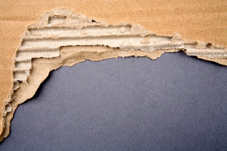 Ripped cardboard on blue backgroundの写真素材