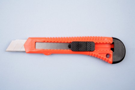 Box cutter knife on blue background の写真素材