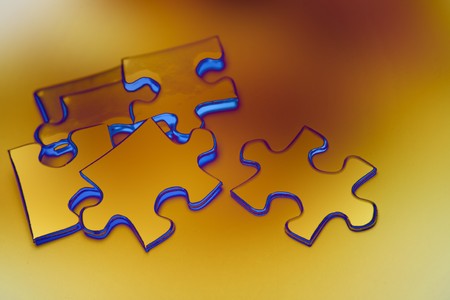 Jigsaw puzzle pieces scattered on color background の写真素材