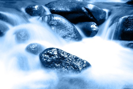 Stream flowing in motion over rocks. Natural background の写真素材