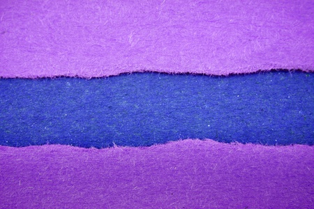 Hole ripped in paper on blue  の写真素材