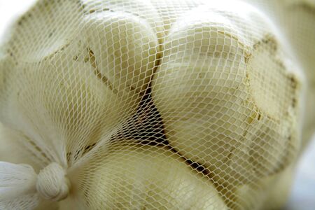 Garlic in net bagの写真素材