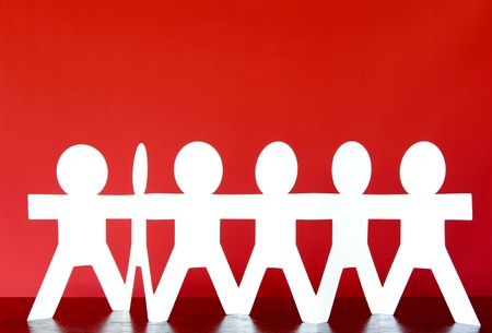Group of paper chain people holding handsの写真素材