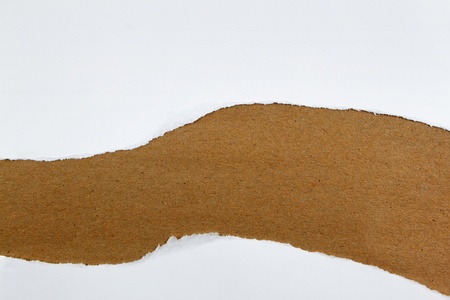 Hole ripped in white paper on brown background  Copy spaceの写真素材