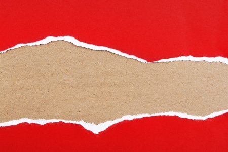Hole ripped in red paper on brown background  Copy spaceの写真素材