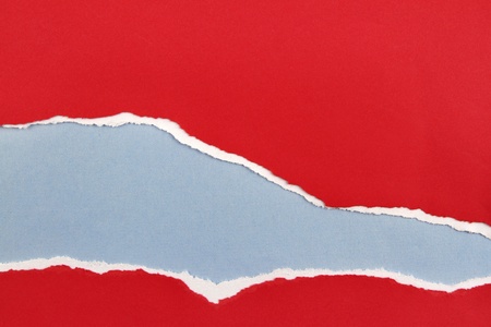 Hole ripped in red paper on blue background  Copy spaceの写真素材
