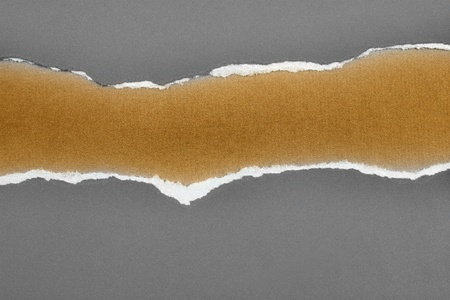 Hole ripped in paper on brown background. Copy spaceの写真素材