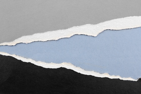 Hole ripped in paper on blue background. Copy spaceの写真素材