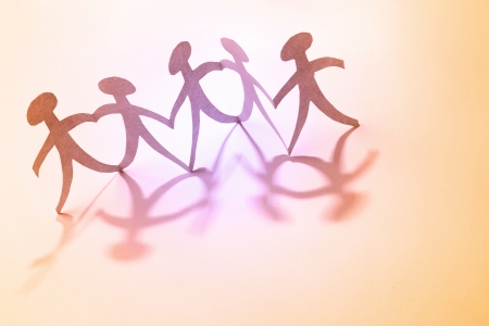 Team of paper doll people holding hands  Teamwork conceptの写真素材