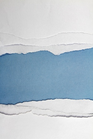 Hole ripped in white paper on blue background  Copy spaceの写真素材