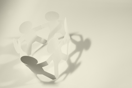 Group of paper doll people in a circle holding hands  Teamwork conceptの写真素材