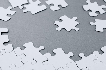Loose jigsaw puzzle pieces on grey background