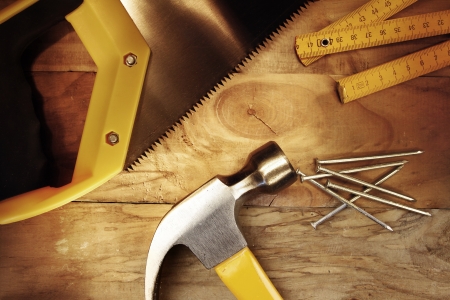 Hammer, nails, ruler and saw on woodの写真素材