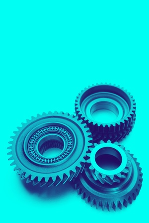 Metal cog gears bonding together on blue backgroundの写真素材