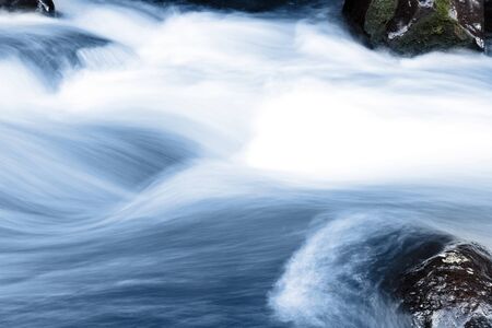 Stream flowing fast over rocksの写真素材