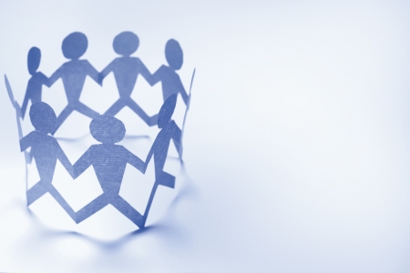 Team of paper doll people holding hands の写真素材