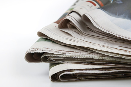 Pile of newspapers on plain backgroundの写真素材