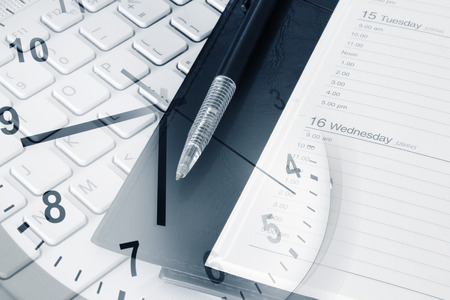 Pen, diary, clock and computer keyboard