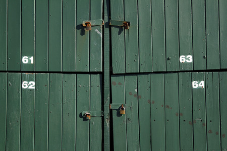 Padlocks on closed green doorsの写真素材