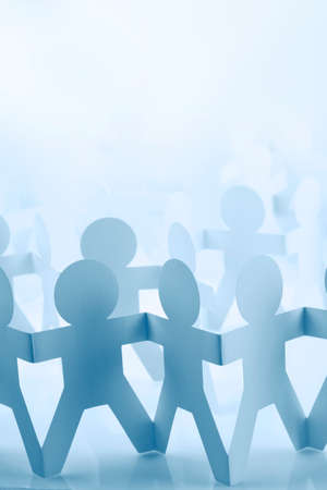 Team of paper doll people holding handsの写真素材