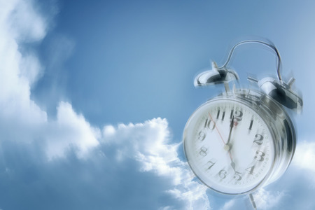 Alarm clock in blue skyの写真素材