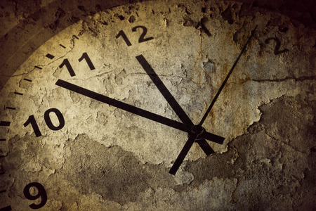 Closeup of hands on grunge clock face