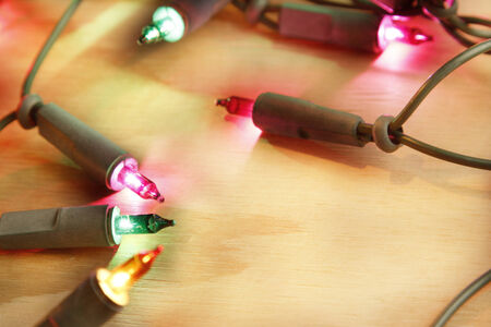 Closeup of Christmas lights glowing on wood