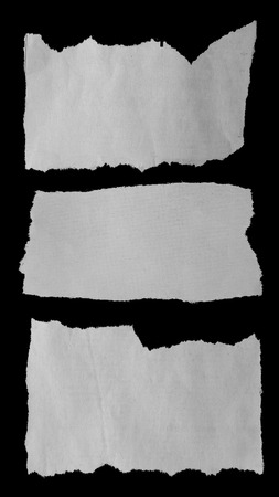 Three pieces of torn paper on black. Copy spaceの写真素材
