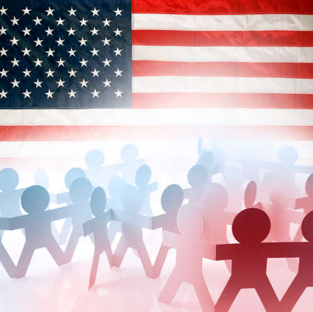 Team of people holding hands and American flagの写真素材