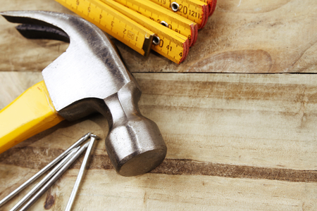 Hammer, nails and folding ruler on woodの写真素材