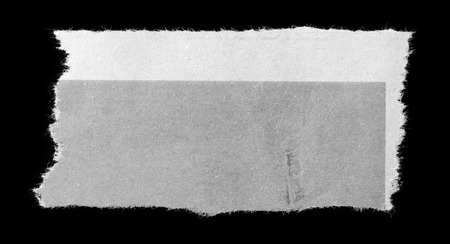 Piece of torn paper on blackの写真素材