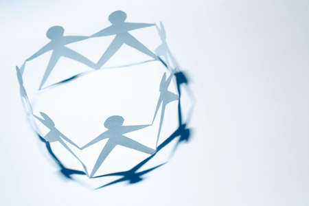 Team of paper doll people holding hands