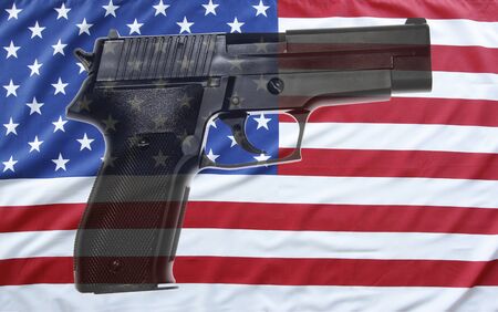 Handgun in front of American flagの写真素材