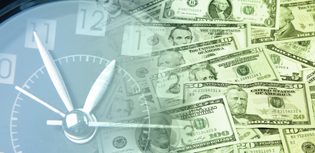 Clock on assorted American banknotes. Time is money ideaの写真素材