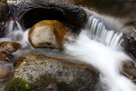 Water flowing over rocks in streamの写真素材