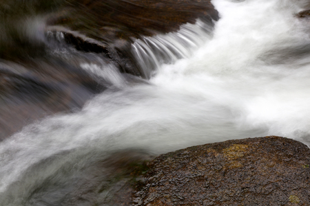 Water flowing over rocks in streamの写真素材
