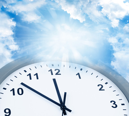 Clock face in blue sky. Time passingの写真素材