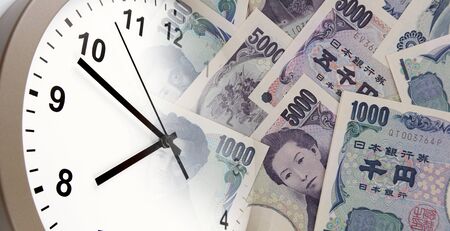 Clock on Japanese Yen banknotes. Time is money ideaの写真素材