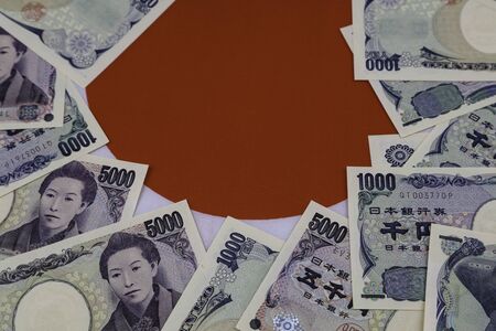 Close-up of Yen banknotes on Japanese flagの写真素材