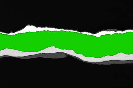 Ripped black paper on green background