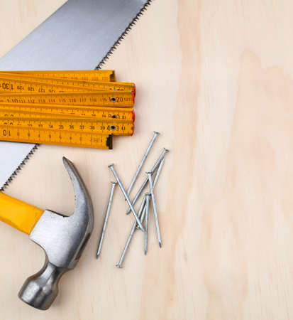 Hammer, nails, ruler and saw on wood. Copy spaceの写真素材