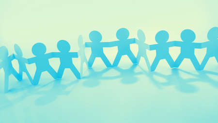 Team of paper chain people united together holding handsの写真素材