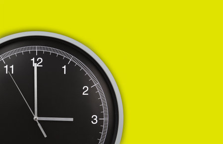 Wall clock showing three o'clock on yellow background. Copy spaceの写真素材